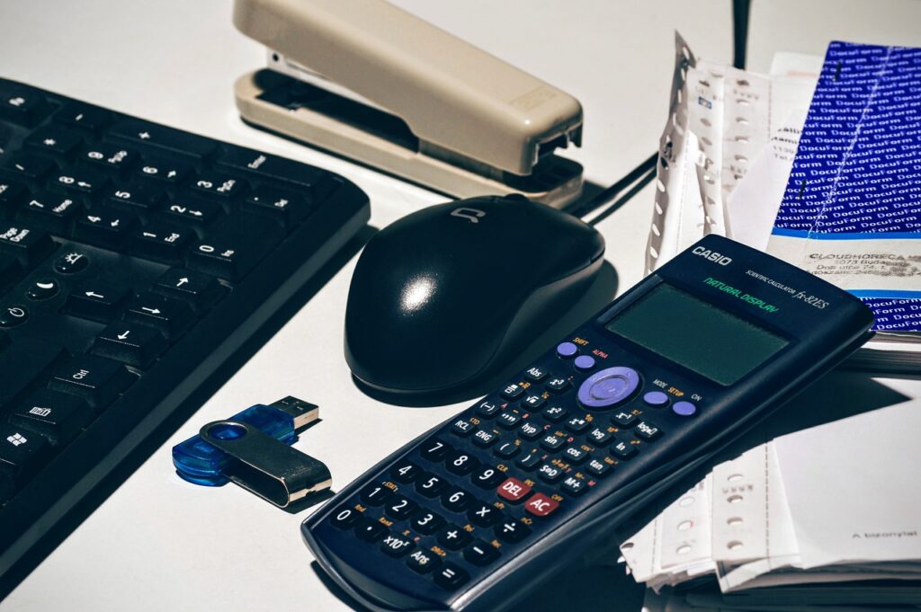 Document comptable pour une entreprise domiciliée en Suisse, accompagné de calculatrices et de dossiers financiers.